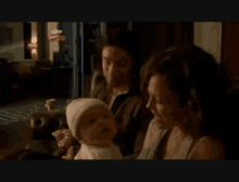 Mitchell And Annie Holding A Baby GIF