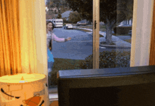 a woman stands in front of a sliding glass door looking out