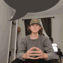 a young man wearing a green hat with the letter r on it
