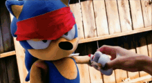 a sonic the hedgehog stuffed animal with a red band around its eyes