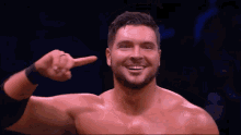 a shirtless wrestler covering his ears with his hand