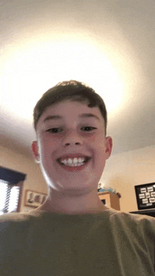 a young boy is smiling for the camera in a room