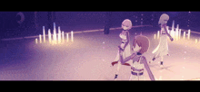 three anime girls are dancing on a stage with candles in the background