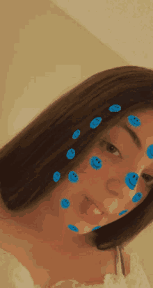 a girl with blue smiley faces on her face