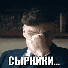 a man in a suit and tie covering his face with his hand and the words сырники