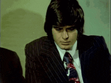 a man in a suit and tie looks at something