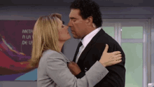 a woman kisses a man in front of a painting that says metro a la de la