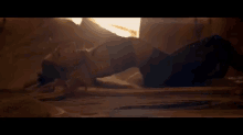 a woman is laying on her stomach on the ground in a dark room .