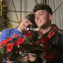 two men are holding flowers and the words te tuve are above them