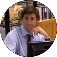 a man in a blue shirt and tie is sitting in front of a computer monitor