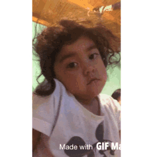 a little girl wearing a mickey mouse shirt is making a funny face