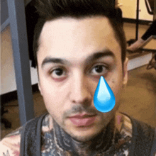a close up of a man 's face with a tear coming out of his eye