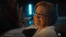 a woman wearing glasses is crying in a nbc show