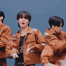 a group of young men are dancing and one of them is wearing a jacket that says converse on it