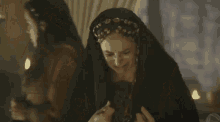 a woman in a black dress is talking to a man in a brown shirt