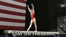 a female gymnast is doing a trick on a balance beam with the words stay on the beam above her