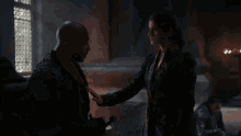 a man and a woman are standing next to each other in a dark room .