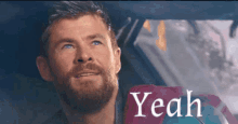 a man with a beard is sitting in a car and the word yeah is on the screen