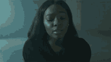 a close up of a woman 's face in a dark room .