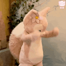 a stuffed animal with a flower in its ear is standing on its hind legs .