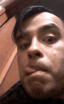 a close up of a man making a face with his tongue out