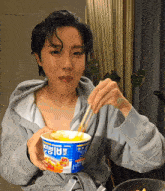 a person eating a bowl of ramen with chopsticks and the word ramen on it