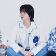 a boy wearing a white shirt with blue flowers on it