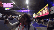 a woman taking a selfie in front of a sign that says " me "