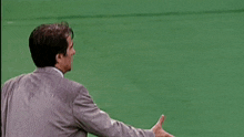 two men in suits are shaking hands on a field