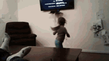 a little girl is jumping in the air in front of a tv that says the end credits