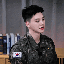 a young man in a military uniform has a korean flag patch on his chest