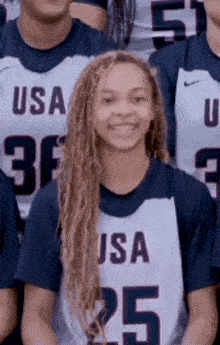 a girl with dreadlocks is posing for a picture with her teammates .