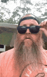 a man with a long beard is wearing sunglasses and a hat