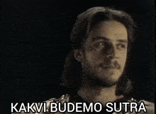 a black and white photo of a man with the words " kakvi budemo sutra " written below him
