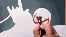 a person is drawing a spiderman with a pencil on a piece of paper