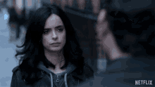 a woman in a leather jacket stands next to a man in a netflix ad