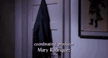 a coat hangs on a door with the name mary rodriguez on it