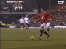 a soccer player in a red jersey kicks the ball