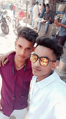 two young men are posing for a picture together on a street .