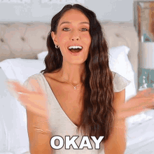 a woman in a white dress says okay in front of her
