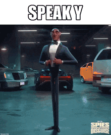 a man in a tuxedo is standing in a parking garage with cars and the words speak y behind him