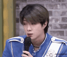 a man in a blue uniform is holding a microphone
