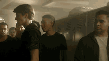 a group of young men are standing in a locker room with smoke coming out of the lockers .
