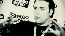 a man stands in front of a wall that says stereo sonic