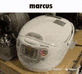 a marcus rice cooker sits on a wooden table