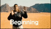 a man is standing in the desert with the word beginning behind him