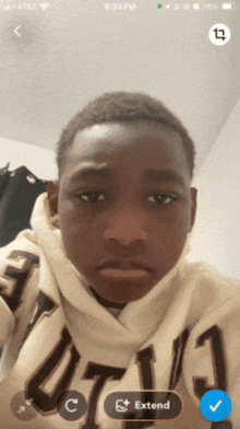 a phone screen shows a boy wearing a hoodie that says utl3