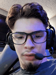 a man wearing glasses and headphones is sitting in front of a samsung monitor