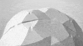 a black and white photo of a geometric shape on a white surface .