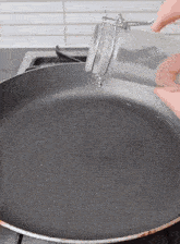 a glass jar is being poured into a pan